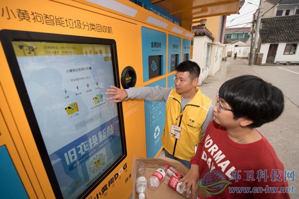 10月30日，在道場鄉(xiāng)錢山下村，工作人員（左）指導(dǎo)村民在智能回收機(jī)上進(jìn)行垃圾分類回收。