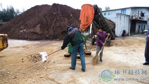 工人將機器碾碎的園林廢棄物鏟入發(fā)酵堆，噴灑生物菌劑攪拌后，自然發(fā)酵兩到四個月，就能成為有機介質(zhì)，用來改良土壤
